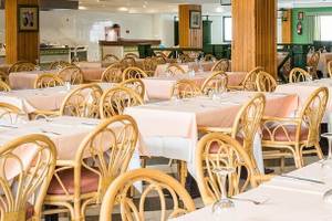 Das innenbereich des Bluesea Costa Bastian Hotels mit eingerichteten tischen und stühlen.