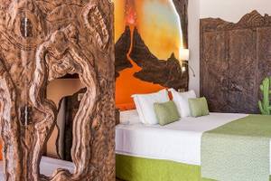 Doppelbettzimmer im Bluesea Costa Bastian Hotel mit vulkanischer Wandmalerei und Kaktusdesign.