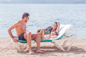 Familie entspannt auf Strandliegen vor dem Doubletree by Hilton Malta Hotel