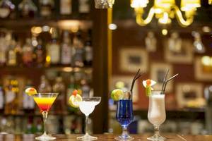 Vier verschiedene Cocktails auf einer Theke im AX The Victoria Hotel.