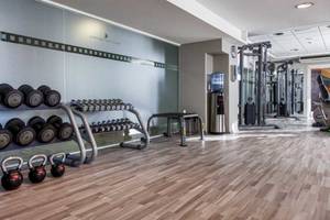 Fitnessstudio im AX The Victoria Hotel mit verschiedenen Gewichten und Geräten.