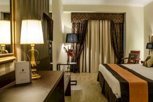 Hotelzimmer im AX The Victoria mit Bett, Lampen und Dekor.