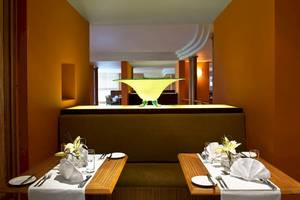 Restauranttisch im Malta Marriott Hotel & Spa mit dekorativen Elementen und Blick auf eine gelbe Leuchte.