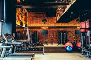 Fitness-Center im Siam@Siam Design Hotel Bangkok mit Laufbändern, Hanteln und Trainingsgeräten.