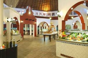Innenbereich des Catalonia Playa Maroma Hotels mit Speisenbuffet und dekorativen Elementen.