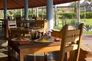Esstisch im Restaurant des Hotels Catalonia Playa Maroma mit Speisen, Gläsern und Dekor.