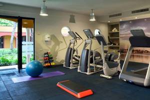 Fitnessraum im Catalonia Playa Maroma Hotel mit Laufbändern, Hanteln und einer großen Kugel.