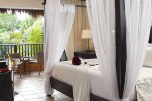 Suite-Bett mit Blick auf den Balkon im Catalonia Playa Maroma Hotel.