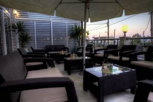 Hotelterrasse mit Sofas und Tischen im Freien bei Sonnenuntergang