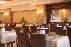 Innenansicht des Restaurants des Side Aluna Hotels mit gedeckten Tischen und dekorativen Wandelementen.