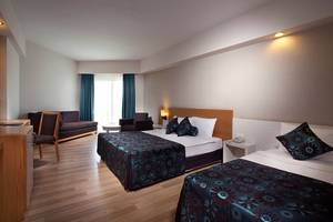 Doppelzimmer im Side Aluna Hotel mit zwei Betten, Sofa, Tisch und Fenstern.