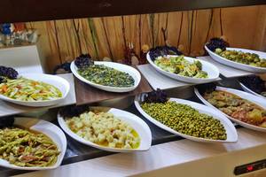 Buffet im Horus Paradise Luxury Resort mit verschiedenen Gerichten wie grünem Gemüse, Erbsen und Tomaten.