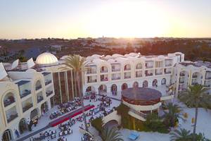 Eden Star Zarzis Hotel Außenansicht bei Sonnenuntergang mit vielen Gästen und Palmen