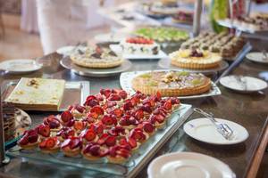 Buffet mit verschiedenen Obstdesserts wie Erdbeeren und Tartes.