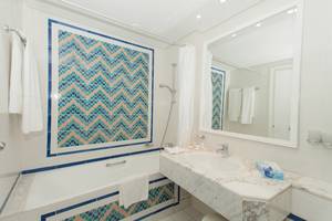 Badezimmer des El Mouradi Palace Hotels mit Badewanne und blauen Kacheln