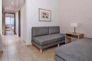 Hotelzimmer des Iberotel Costa Mares mit grauen Sofas und Nachttisch mit Lampe.