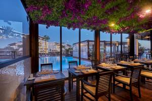 Innenbereich des Restaurants im Secrets Lanzarote Resort & Spa mit Blick auf den Pool.
