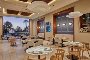Innenraum des Restaurants im Secrets Lanzarote Resort & Spa mit modernen Möbeln und Meeresblick.
