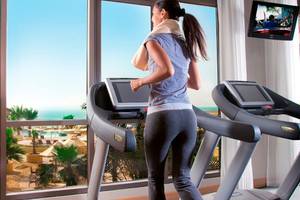 Frau im Amwaj Rotana Hotel auf dem Laufband trainieren mit Blick auf das Meer