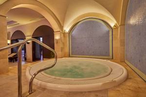 Jacuzzi im Secrets Lanzarote Resort & Spa mit blauen Wandfliesen und Marmorboden.