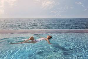 Frau im Burj Al Arab Jumeirah Hotel Pool schwimmen