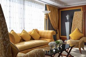 Wohnzimmer im Burj Al Arab Jumeirah mit gelben Möbeln und einer Glastisch.