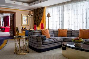 Wohnzimmer im Burj Al Arab Jumeirah Hotel mit blauen und orangefarbenen Möbeln und einem großen Sofa.