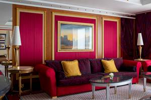 Innenraum des Burj Al Arab Jumeirah Hotels mit rotem Dekor, Sofas und Tischlampen.