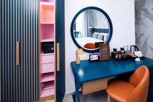 Zimmer im C Central Hotel & Resort The Palm mit Schreibtisch, Stuhl und Spiegel.