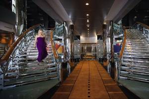 Eine Frau in einem lila Kleid läuft die Treppe eines Hotels hinauf.
