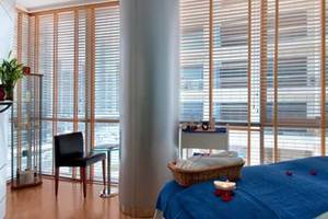 Hotelzimmer im Golden Sands Hotel Creek mit blauem Bett, Kerze, und Blick auf die Stadt.