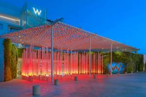 W Ibiza Hotel Eingang mit roten Lichtern und grüner Wand