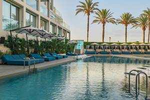 Außenpool des W Ibiza Hotels mit blauen Liegen und Sonnenschirmen