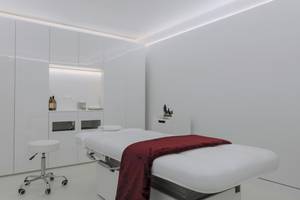 Behandlungsraum im W Ibiza Hotel mit weißem Behandlungstisch, rotem Tuch und weißem Stuhl