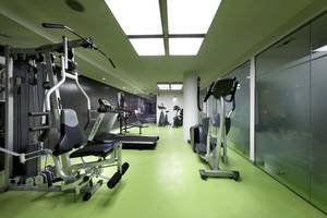 Fitnessbereich im Hotel Sentido Garbi Ibiza mit grünen Böden und modernen Geräten.