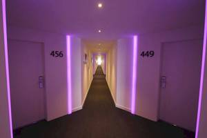 Ein Korridor im Sentido Garbi Ibiza & Spa Hotel mit lila Beleuchtung und Zimmernummern 456 und 449.