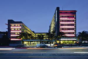 Das Hotel Victor South Beach ist in der Nacht beleuchtet und zeigt seine leuchtenden rosafarbenen Fassaden.
