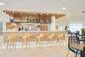 Innenansicht der Rezeption des Universal Aparthotel Elisa mit Bar und Stühle.