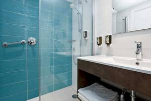 Badezimmer im Universal Aparthotel Elisa mit blauen Fliesen und Dusche