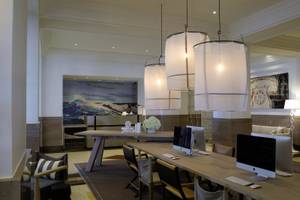 Arbeitsbereich im Victor South Beach Hotel mit Computern, Stühlen und Lampen.