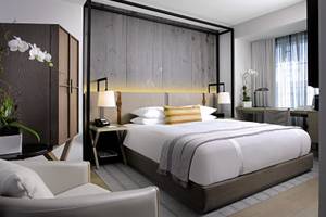 Victor South Beach Hotelzimmer mit Bett, Schreibtisch und Blumendekor.