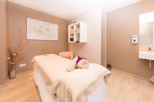 Massageraum im Be Live Adults Only Marivent Hotel mit Behandlungsliege, Stühlen und Dekoration.