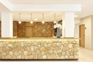 Empfangsbereich des Castell Royal Hotels mit Steinwand und Holzmustern