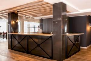 Rezeption im Florida Magaluf Hotel mit Holzboden und schwarzen Metallelementen.