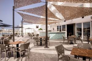 Terrasse des Florida Magaluf Hotels mit Tischen und Stühlen unter Sonnenschirmen.