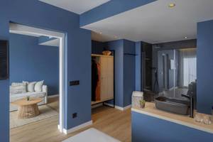 Inneneinrichtung eines Zimmers im Florida Magaluf Hotel mit blauen Wänden, Holzboden und modernem Badezimmer.