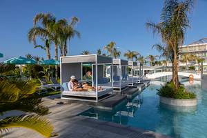 Außenbereich des Faros Hotel Ayia Napa mit Loungeliegen am Pool.
