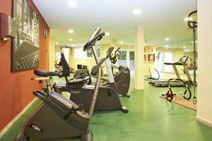 Fitnessraum im Grand Leon & Spa mit verschiedenen Trainingsgeräten und einem Spiegel