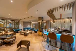 Innenansicht der Lounge im Faros Hotel Ayia Napa mit modernen Möbeln und einer Theke.