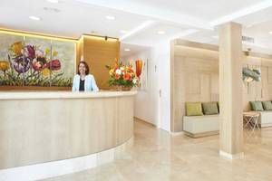 Rezeption des Laguna Hotels mit lächelnder Frau und Blumenarrangement